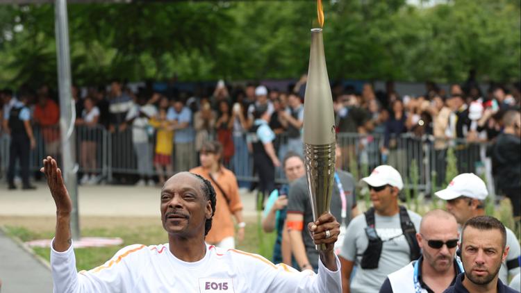 Snoop Dogg carries the Olympic torch before Opening Ceremony in Paris