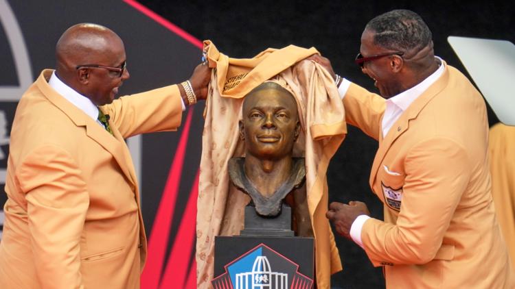 Sterling Sharpe gives fellow Pro Football Hall of Fame brother Shannon his gold jacket